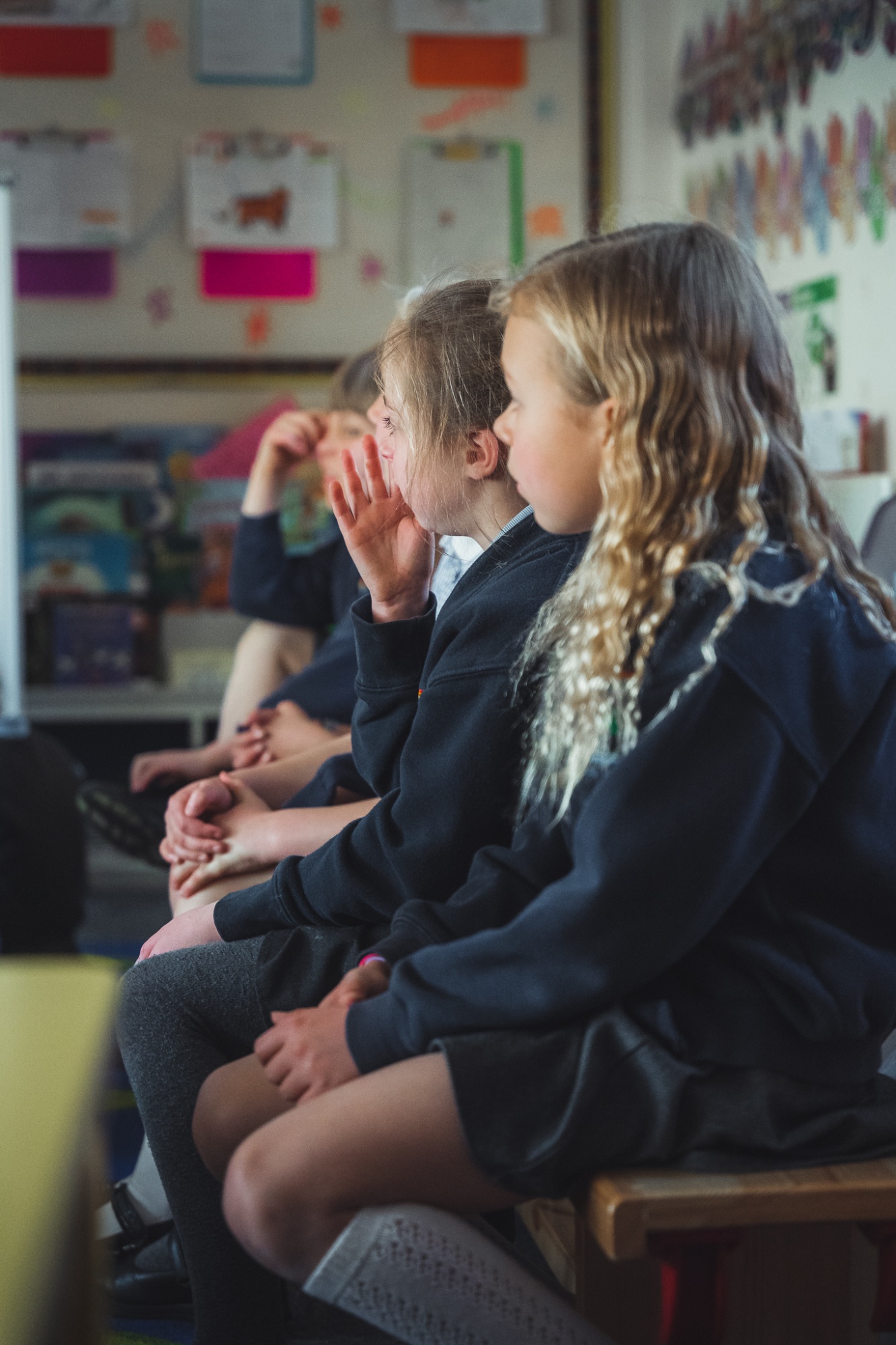 students sat on bench watching teacher