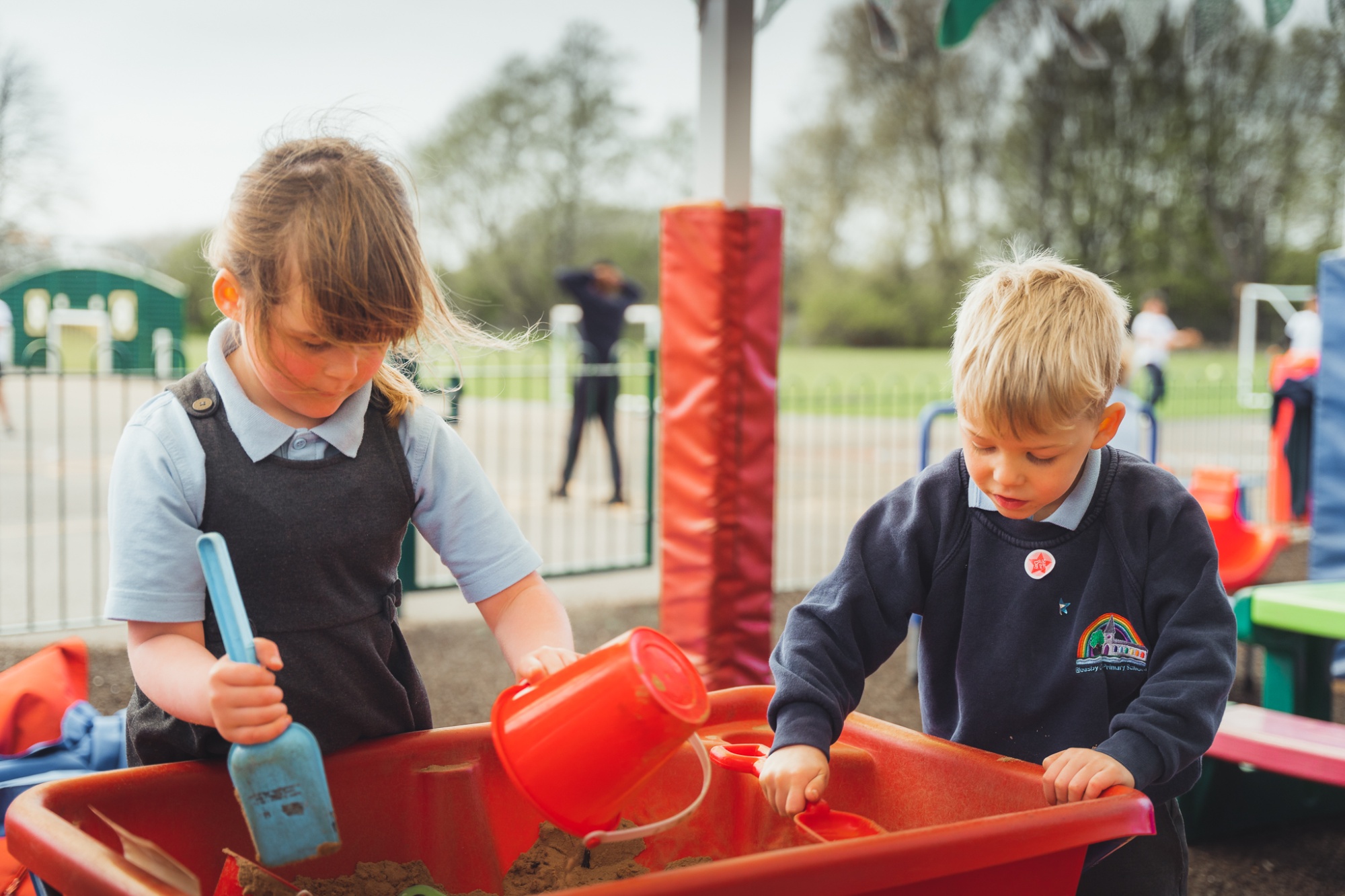 two students playing in the sandpit